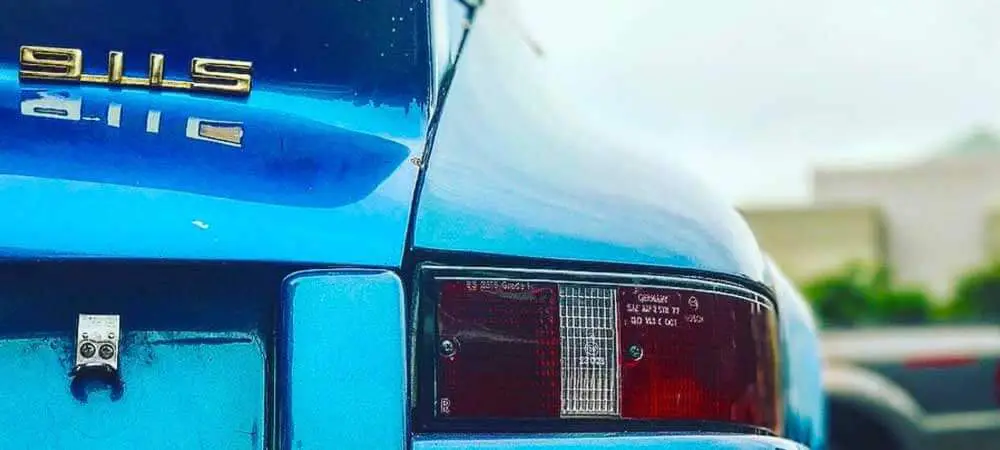 Close of the tail of a blue Porsche car.