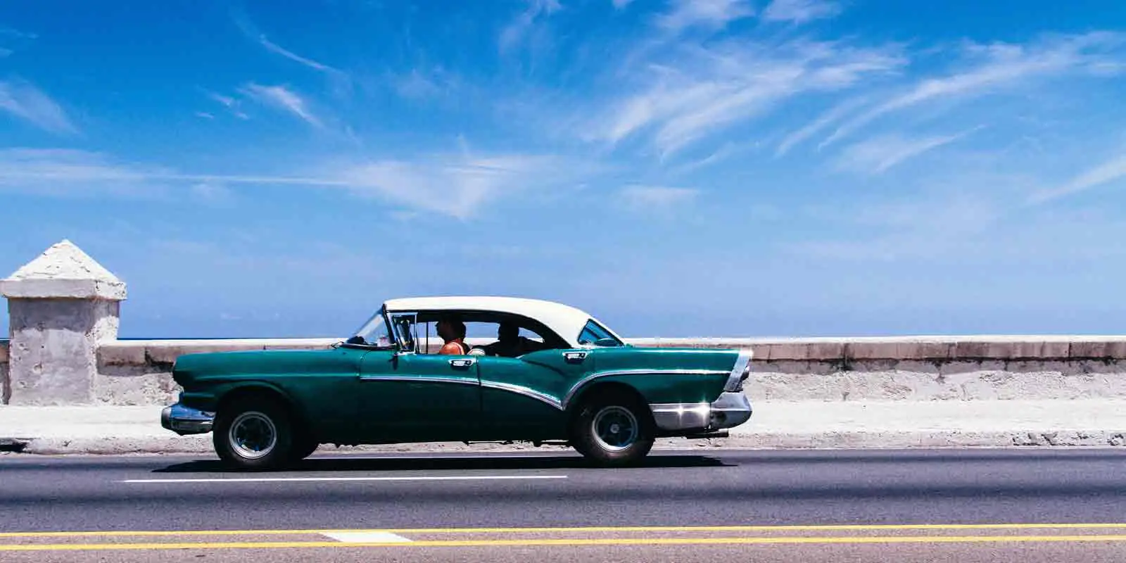 A classic car driving the coast of Cuba, a common site.