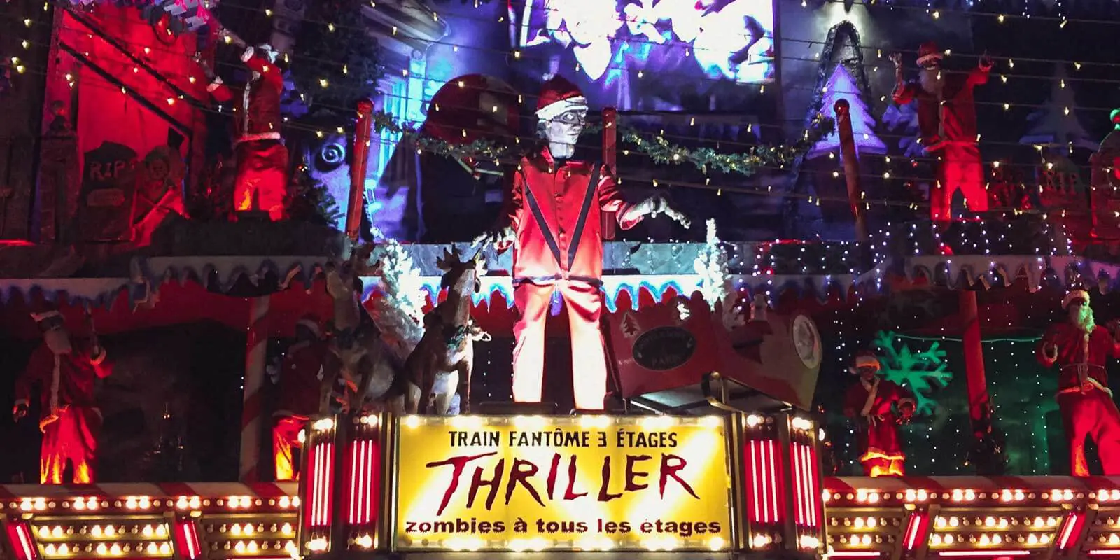 Closeup of the outside of a Christmas, zombie, and Michael Jackson's Thriller themed ride at a Christmas market in Paris.