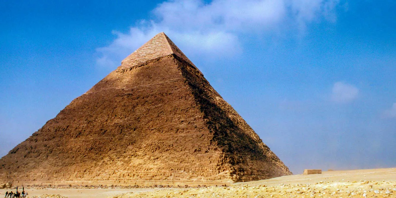 Great Pyramid in Egypt against a bright blue sky.