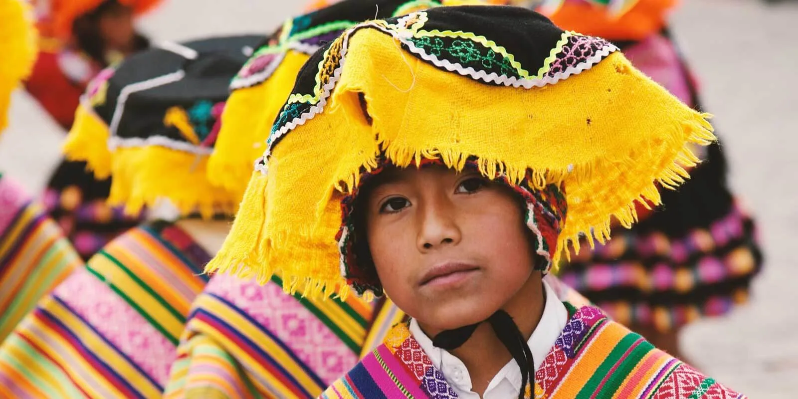 Closeup of a Peruvian child wearing colorful woven hat and clothing.