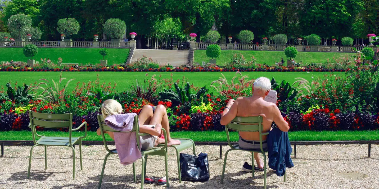 Woman and man enjoying a warm day in Le Jardin du Luxembourg in Paris.
