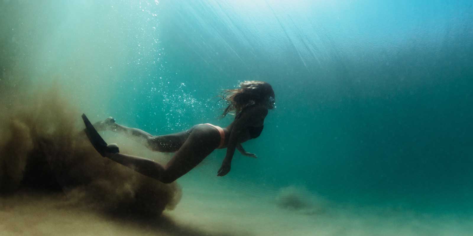 Woman under water, free diving off the coast of Sri Lanka.