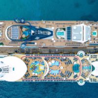 Aerial view of 2 cruise ships docked side by side.