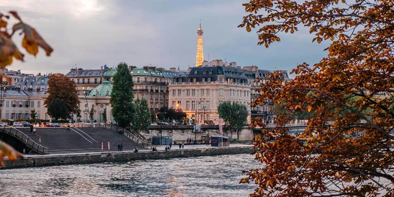 Landscape view of the Paris riverbank with the Eiffel Tower in the distance.