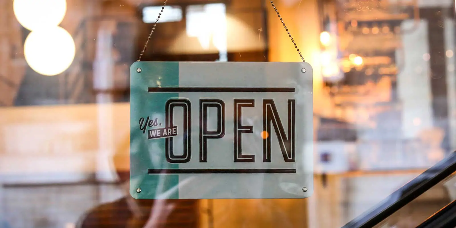 Close up photo of a shop sign saying "Yes, we are open."