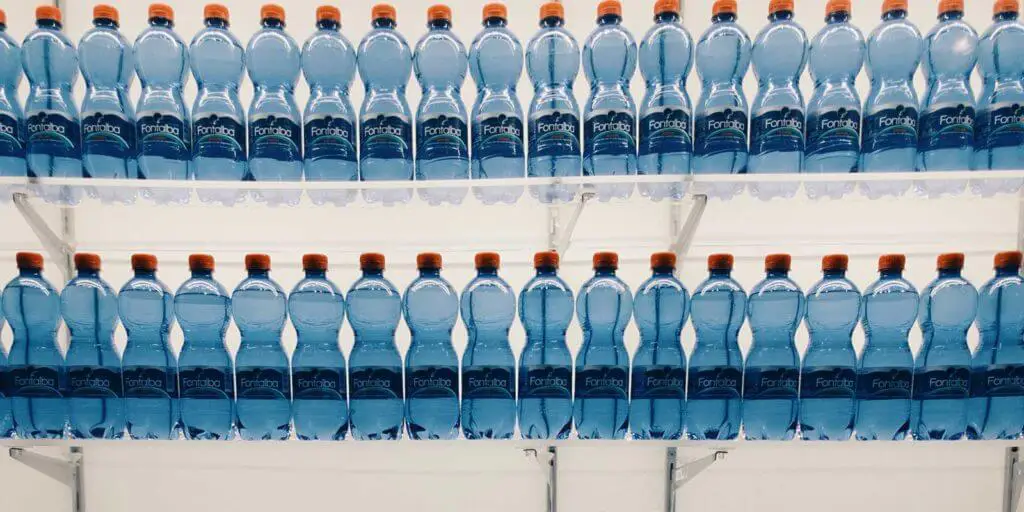 Photo of two shelves full of single use bottles of water.