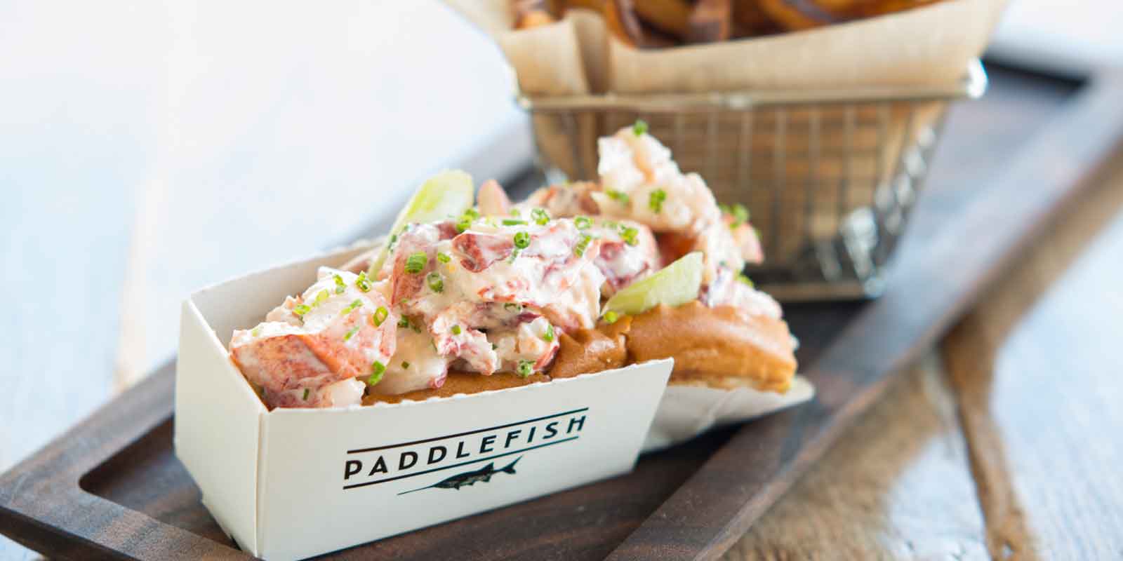 Close up of a lobster roll and bucket of french fries from Paddlefish.