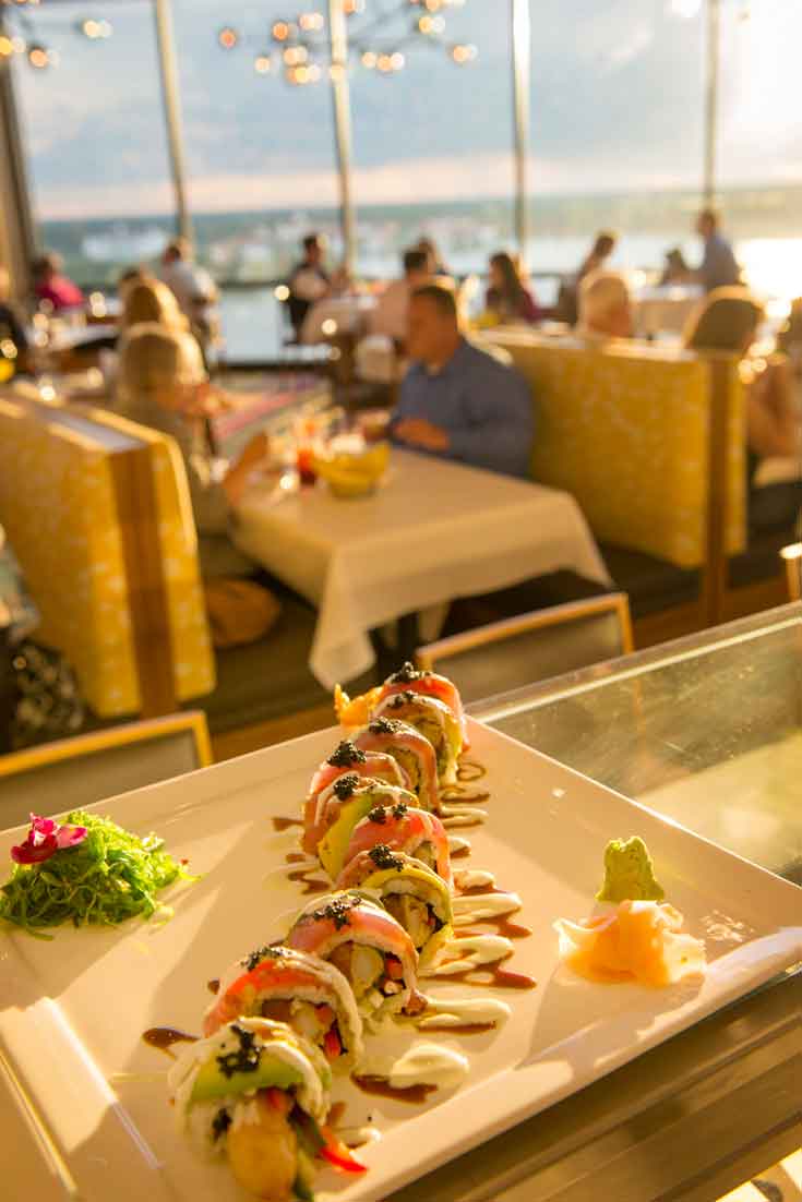 Close up photo of a special sushi roll with diners in the background at California Grill.