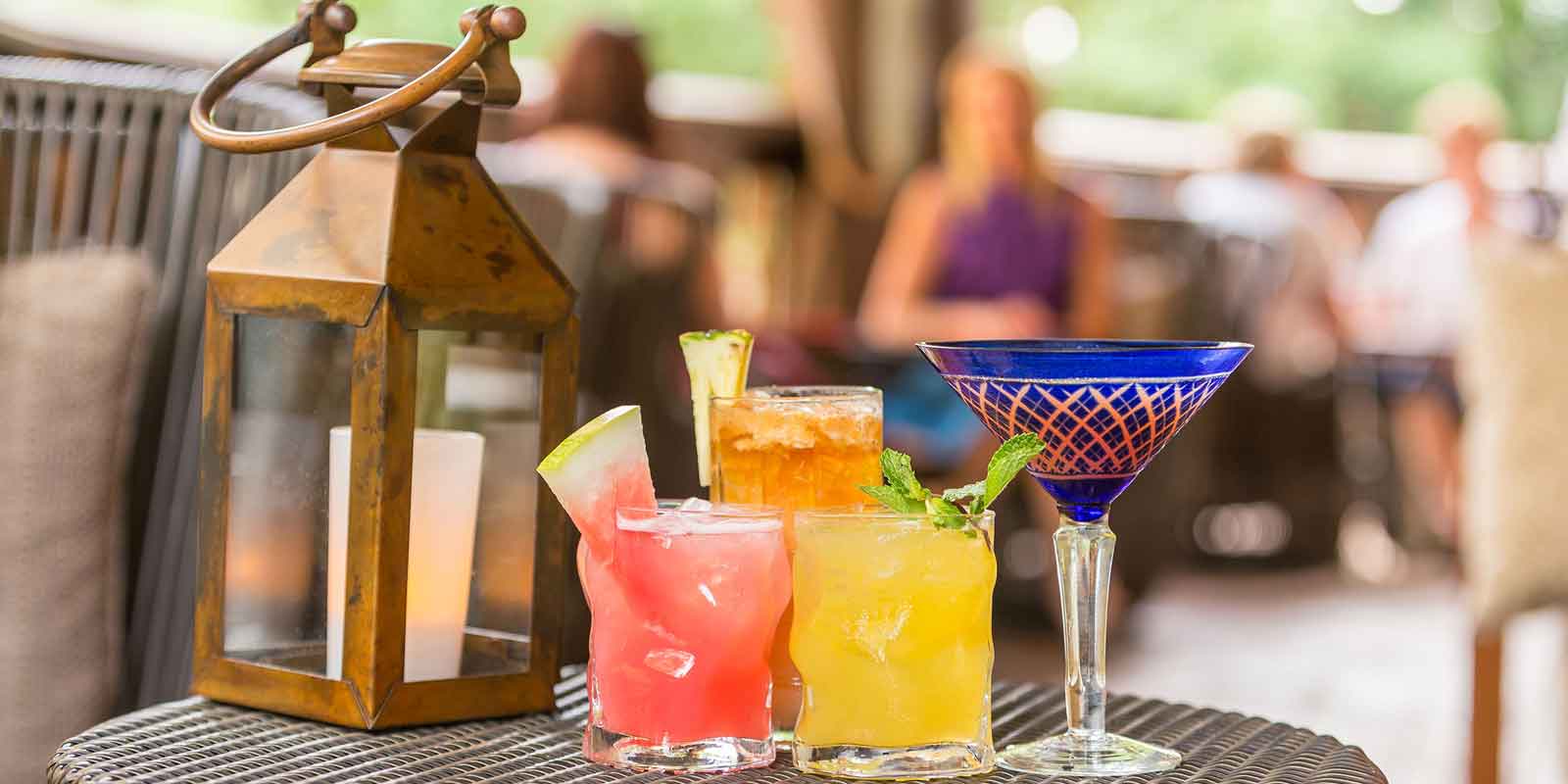 Closeup of 4 brightly colored cocktails on a lounge table at Animal Kingdom's Nomad Lounge.