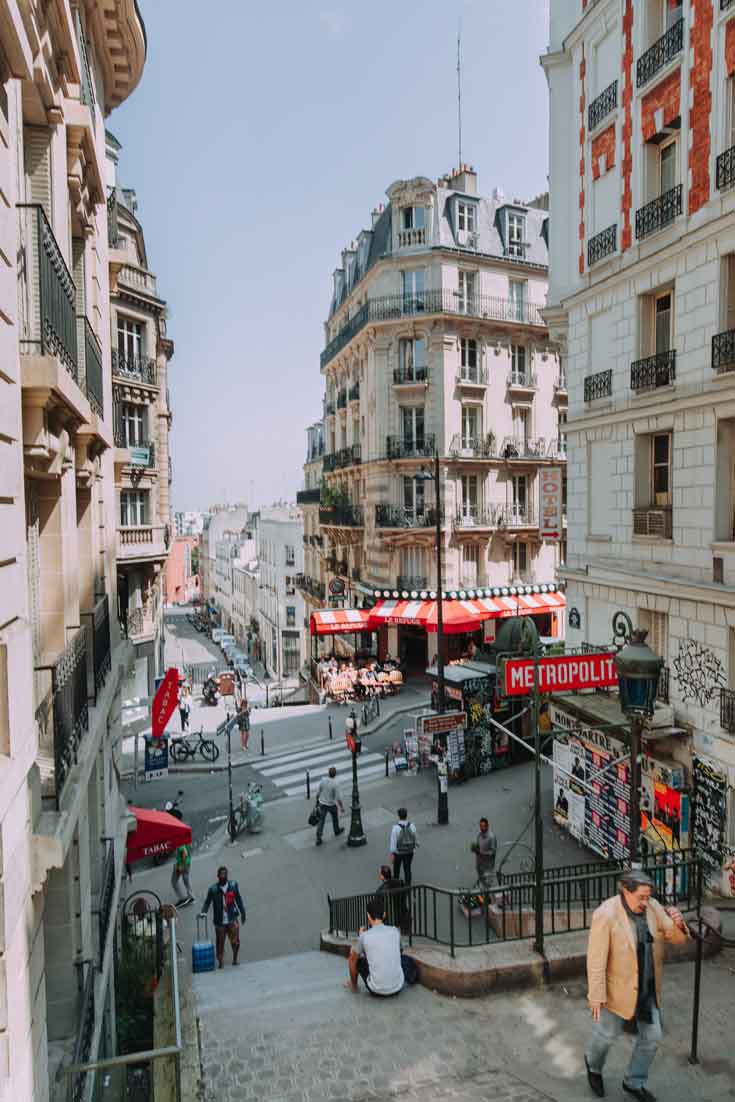 Portrait view of a Parisian neighborhood with a Metro station in the background.