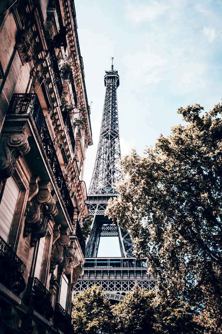 Portrait view of the Eiffel Tower from a nearby side street.