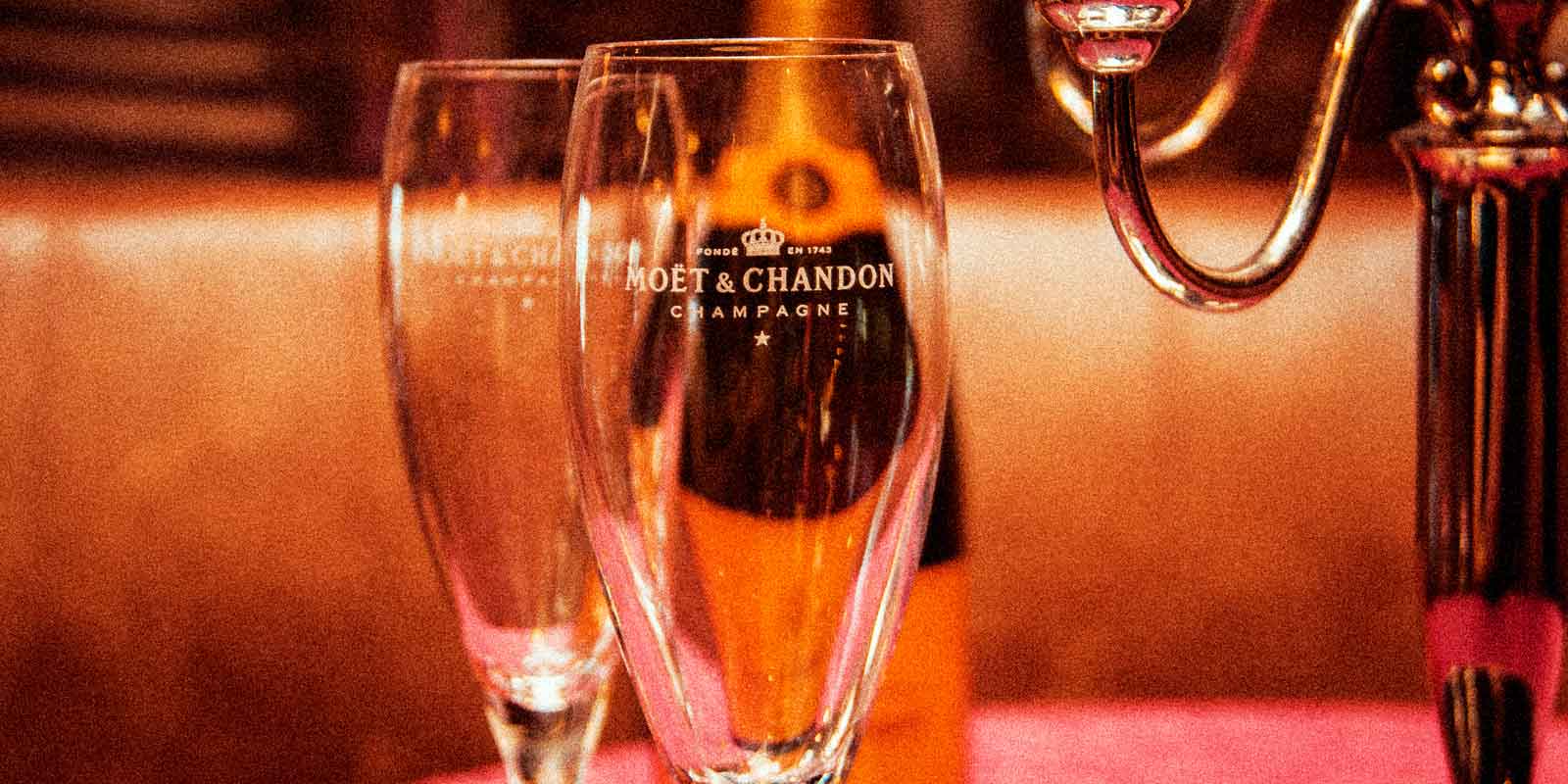 Closeup of 2 champagne glasses with the Moët & Chandon label.