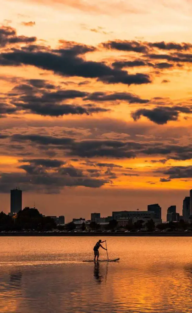 Man paddleboarding in the ocean nearby Castle Island in South Boston