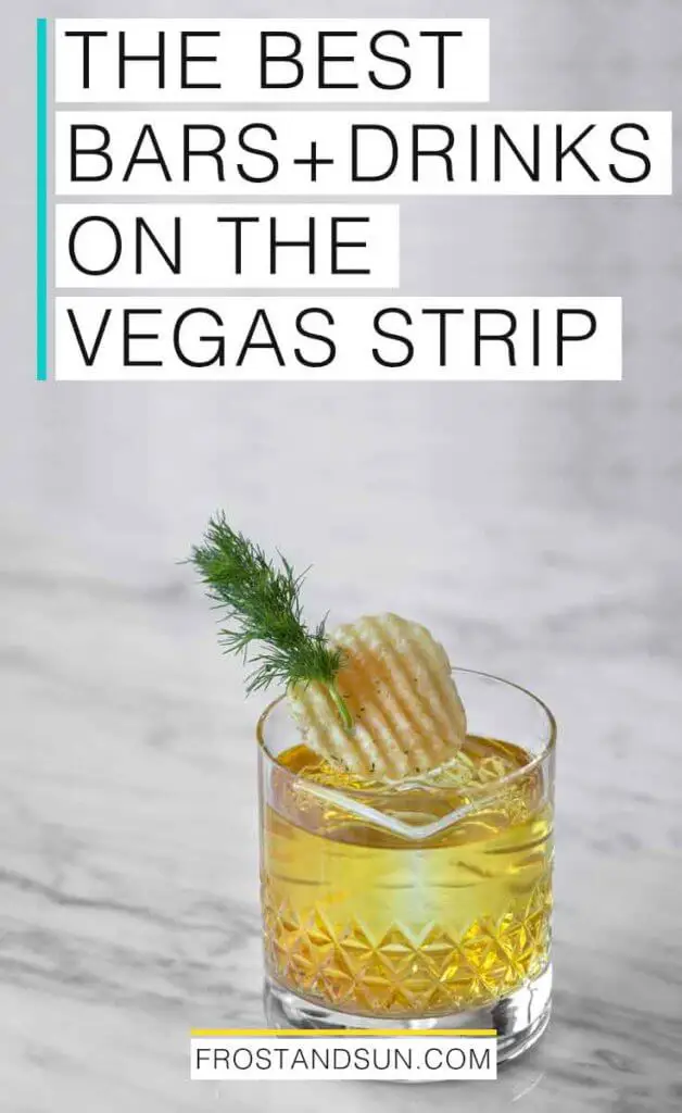Closeup of a yellow tinted cocktail garnished with a potato chip and sprig of dill on top of a grey and white marble counter. Overlying text reads "The Best Bars + Drinks on the Vegas Strip."