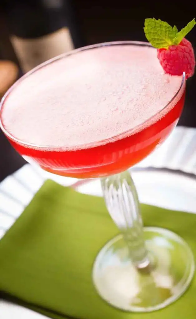 Closeup of cherry pink cocktail with millions of bubbles on the surface in a margarita glass.
