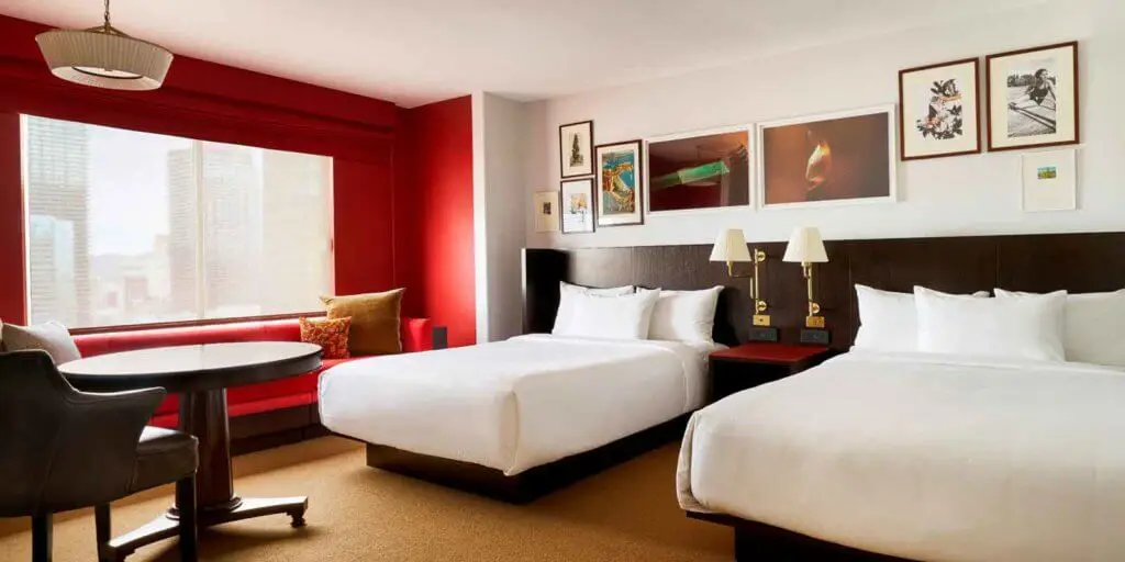 Landscape view of a Park MGM room with 2 Queen beds with a red accent wall.