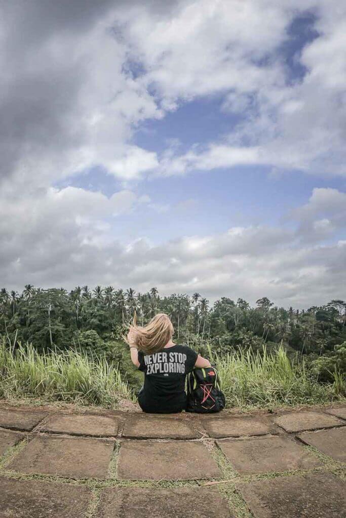 Adventure travel blogger overlooking a tropical forest from a ridge.