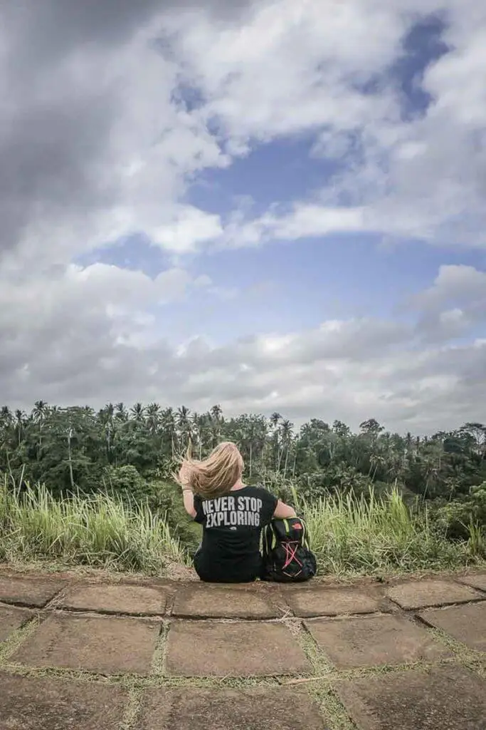 Adventure travel blogger overlooking a tropical forest from a ridge.