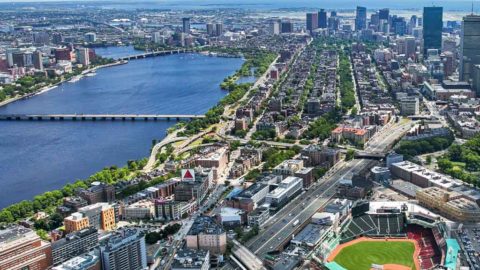 Aerial view of Boston, MA with the Major League Baseball Boston Red Sox's Fenway Park in the foreground. Boston sports tickets can be pricey, but discounts are available for those on a budget!