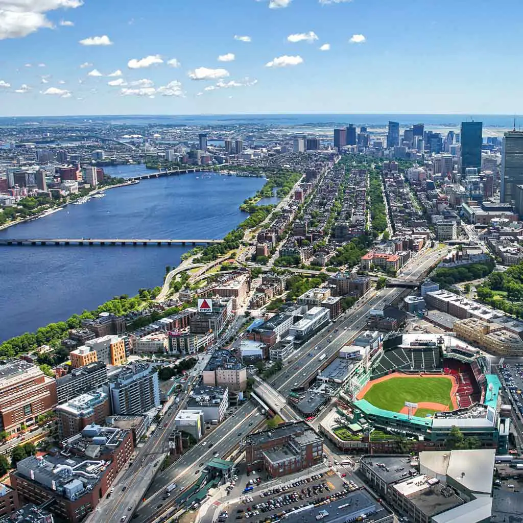 Aerial view of Boston, MA with the Major League Baseball Boston Red Sox's Fenway Park in the foreground. Boston sports tickets can be pricey, but discounts are available for those on a budget!