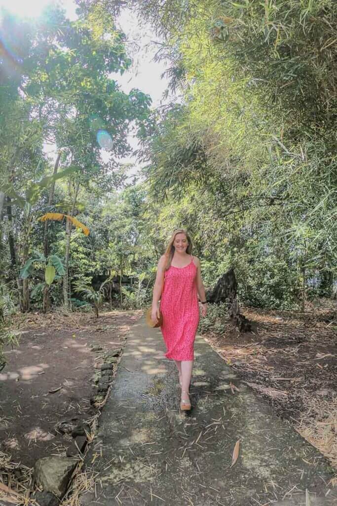 Female travel blogger walking down a path in a tropical forest