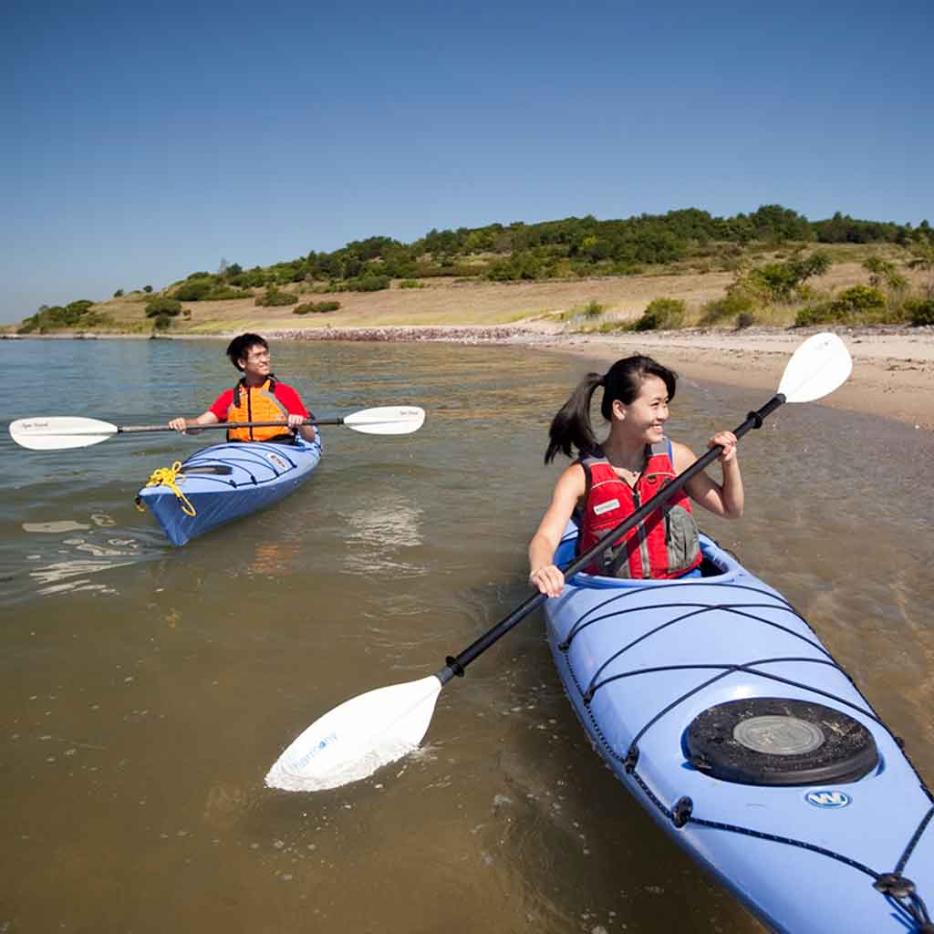 A man and woman kayaking off the coast of one of the Boston Harbor islands.