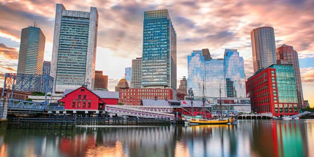 A view of one of Boston's waterfront neighborhoods with buildings reflecting on the water.