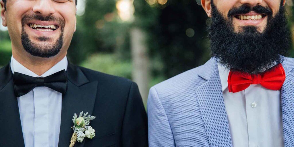 Closeup of two men in suits, smiling.