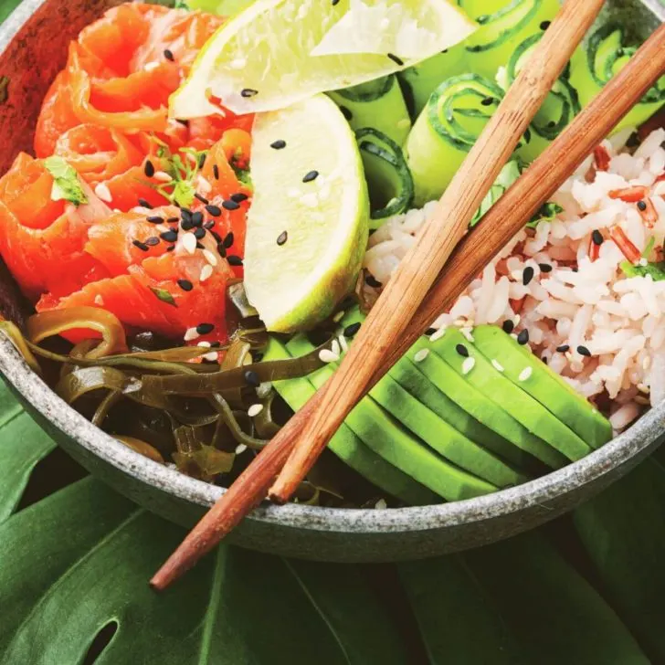 Closeup of a Hawaiian poke bowl with a pair of chopsticks across the top.