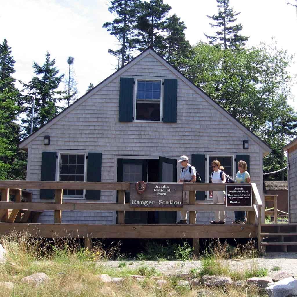 Photo of a small cottage-like building with a sign that says "Acadia National Park Ranger Station."