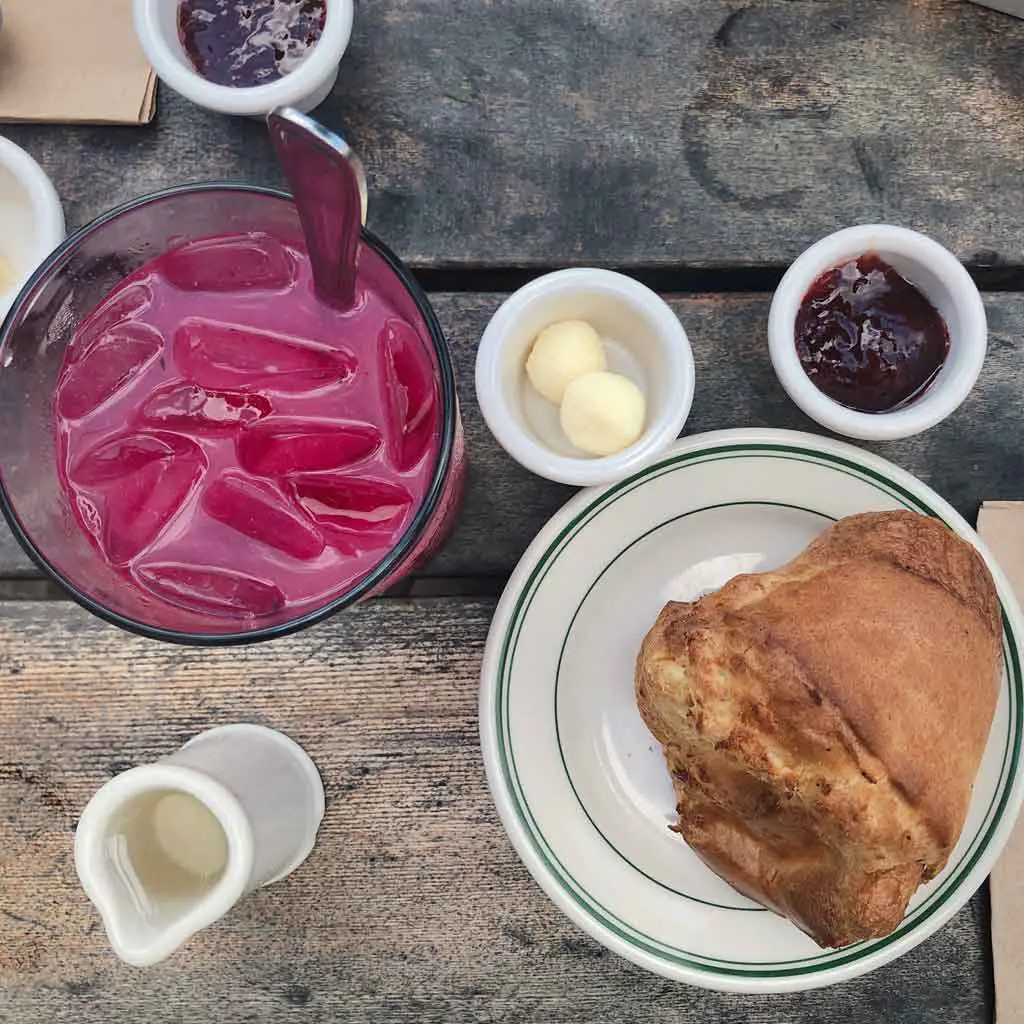 Flat lay photograph of blueberry lemonade and a popover with fresh jam and butter at Jordan Pond House.