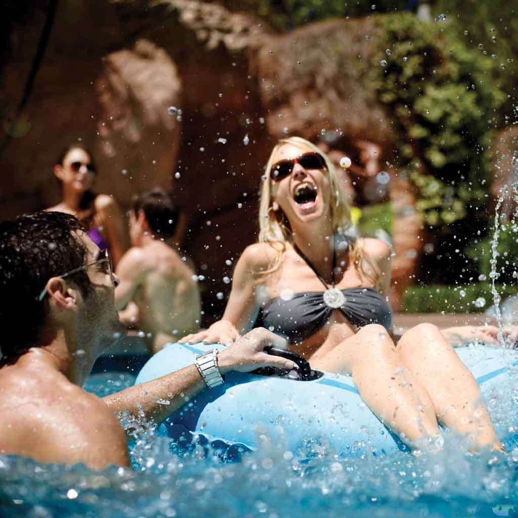 Woman sitting in a float laughing with a male companion standing next to her.