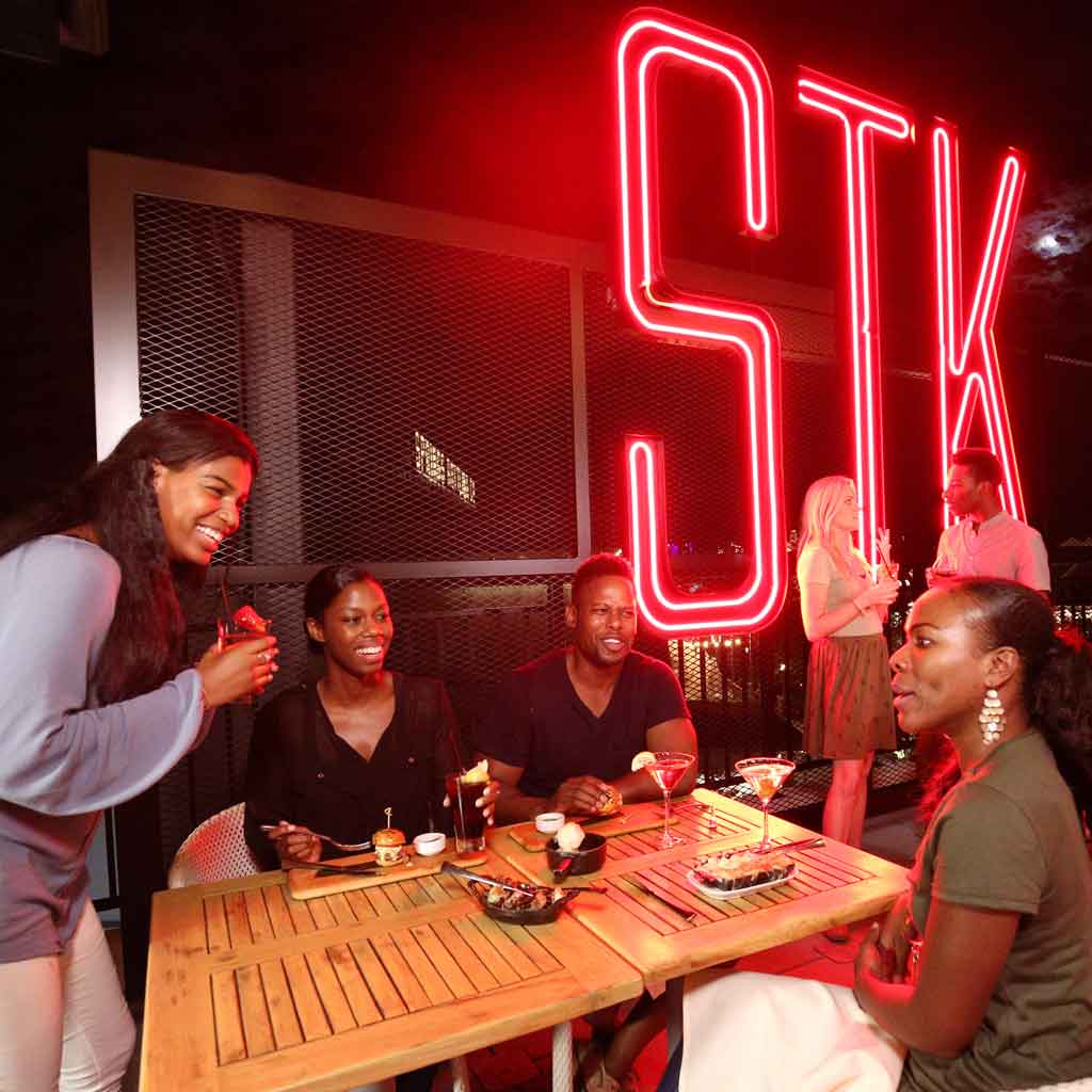 Landscape photo of a group of 4 friends at STK restaurant.