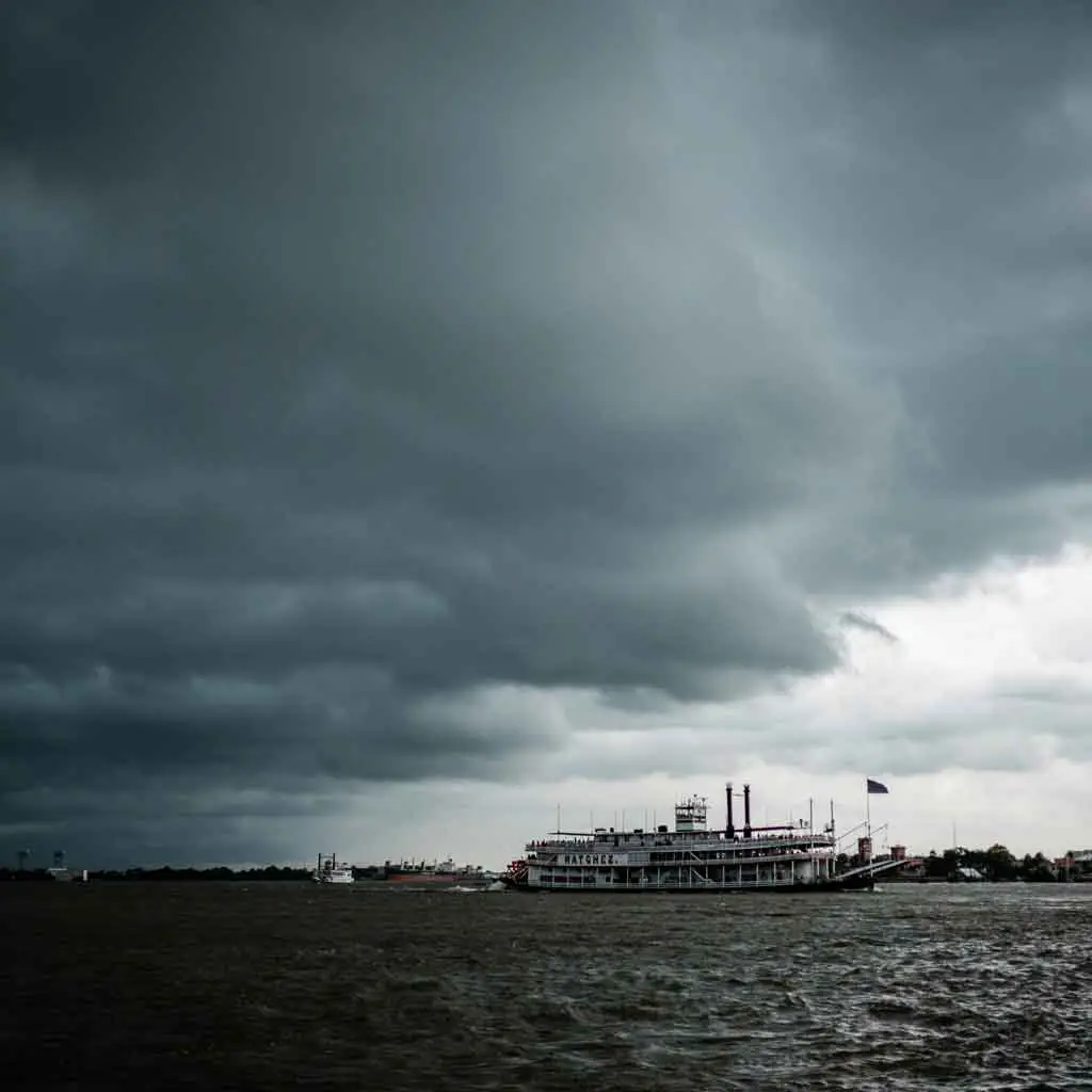 Photo of the Natchez steamboat on the Mississippi River in gray, stormy weather.