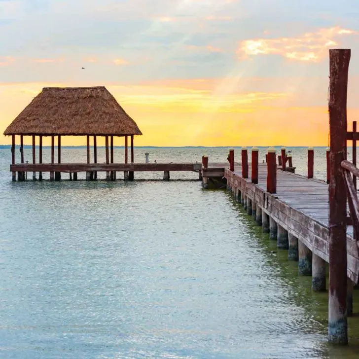 Landscape view of a dock leading out into the ocean with a pavilion at the end.