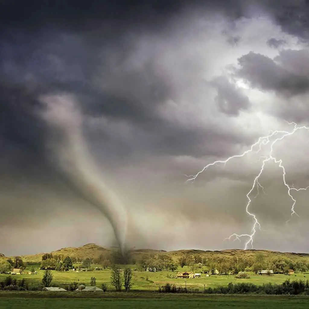 Landscape photo of a tornado touching ground and lightening striking at the same time.