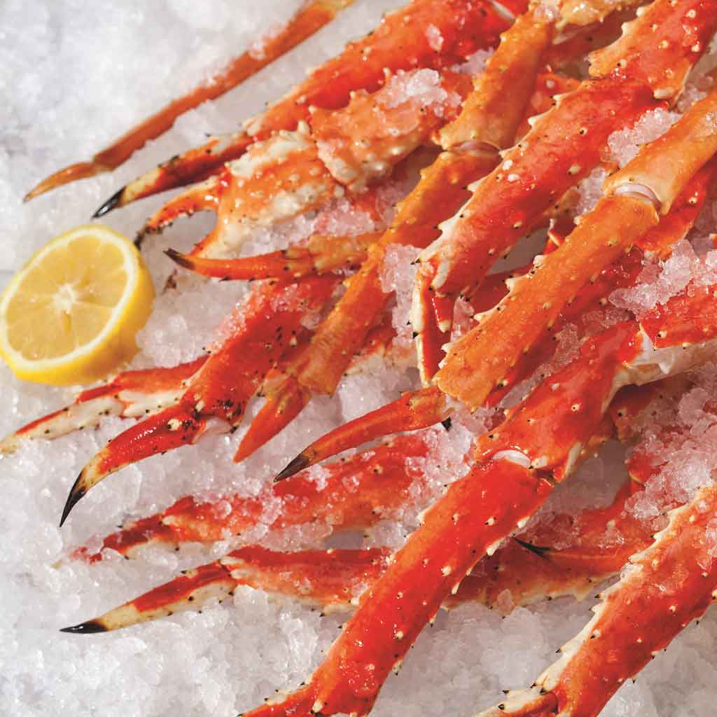 Closeup of a pile of crab legs on ice.