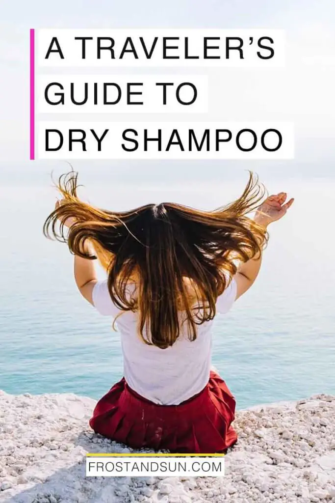 Photo of woman sitting on a cliff overlooking the ocean with her back to the camera, flipping her hair in the air.Overlying text reads "A Traveler's Guide to Dry Shampoo."