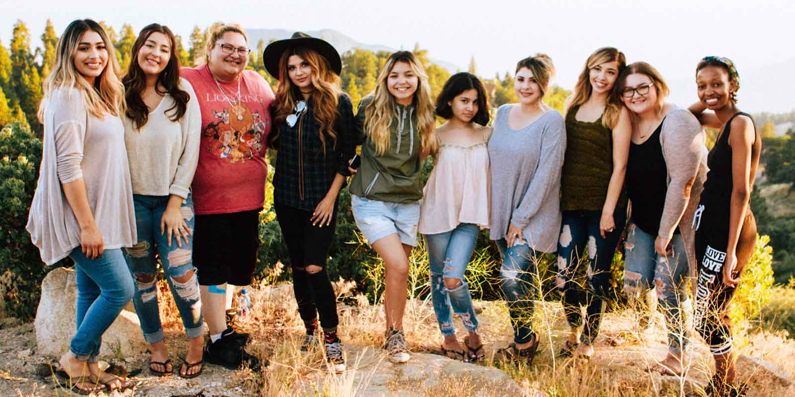 Photo of a group of 10 women posing together outdoors.