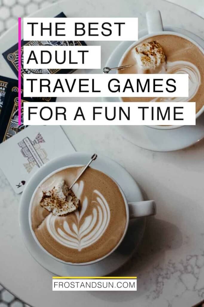 Aerial photo of a small marble table with 2 cups of hot chocolate and playing cards on top. Overlying text reads "The Best Adult Travel Games for a Fun Time."