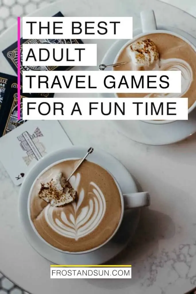 Aerial photo of a small marble table with 2 cups of hot chocolate and playing cards on top. Overlying text reads "The Best Adult Travel Games for a Fun Time."