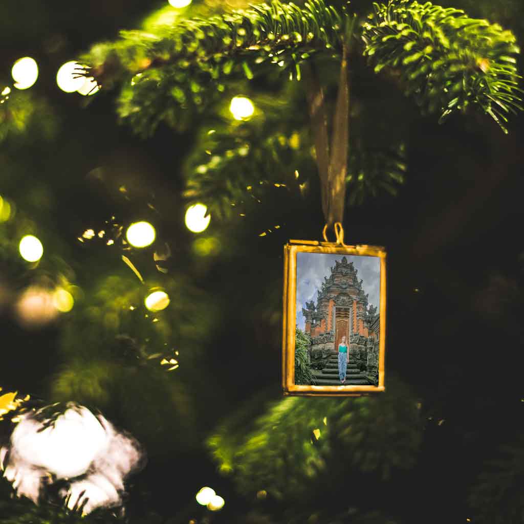 Closeup of a photo framed ornament on a Christmas tree.