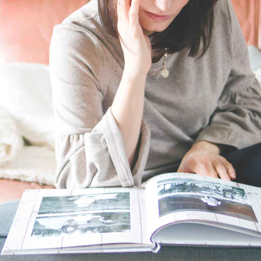 Picture of a woman looking at a photo book.