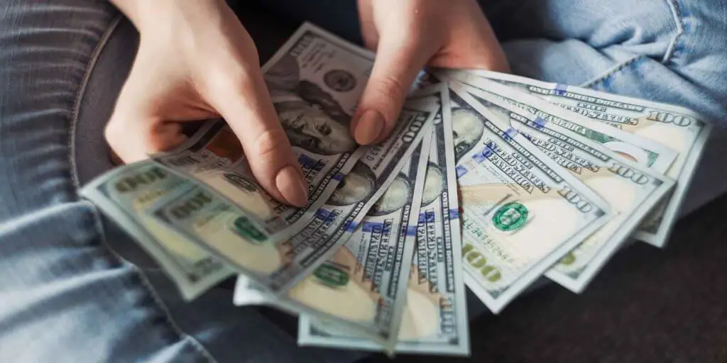 Closeup of a person holding US dollars fanned out.