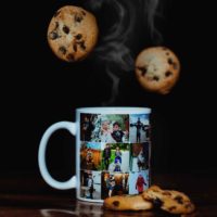 Picture of a mug with photos printed on it. Chocolate chip cookies are arranged next to the mug with another 2 cookies falling from above.