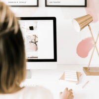 Closeup of a woman looking at a Mac desktop screen with photos displayed on it.