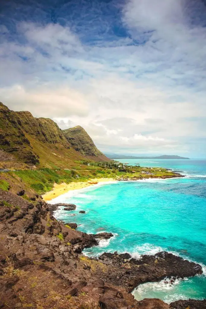 Photo of a coastal landscape in Hawaii with rocky cliffs and turquoise water.