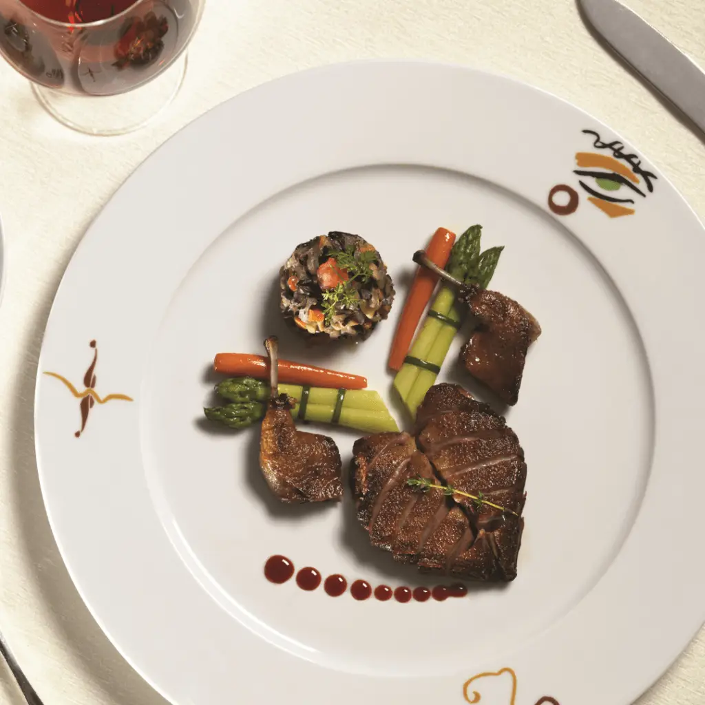 Photo of a steak and veggies displayed like an abstract heart.