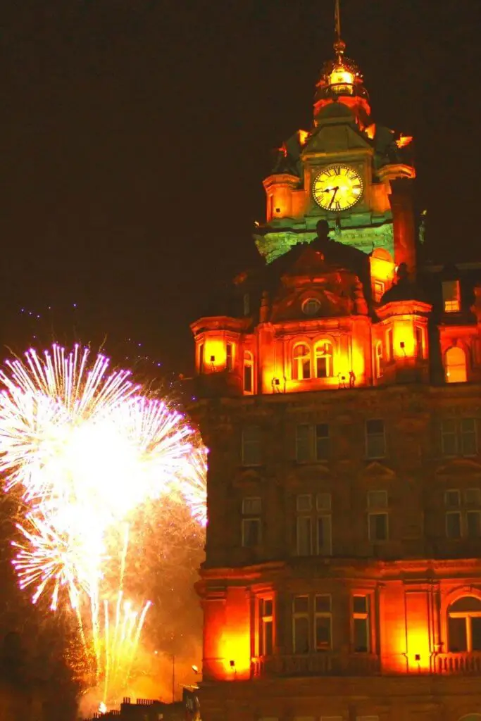 Photo of a building in Edinburgh, Scotland with fireworks exploding behind it.